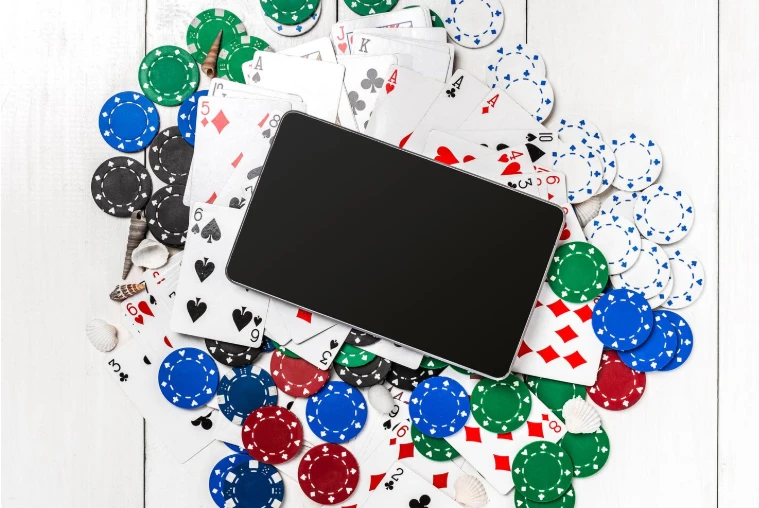 Mobiltelefon omgitt av spillekort og casinosjetonger