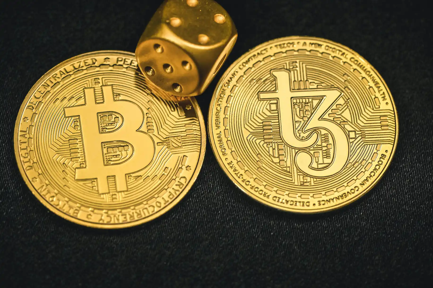 Bitcoin- og Tezos-mynter med en gyllen terning