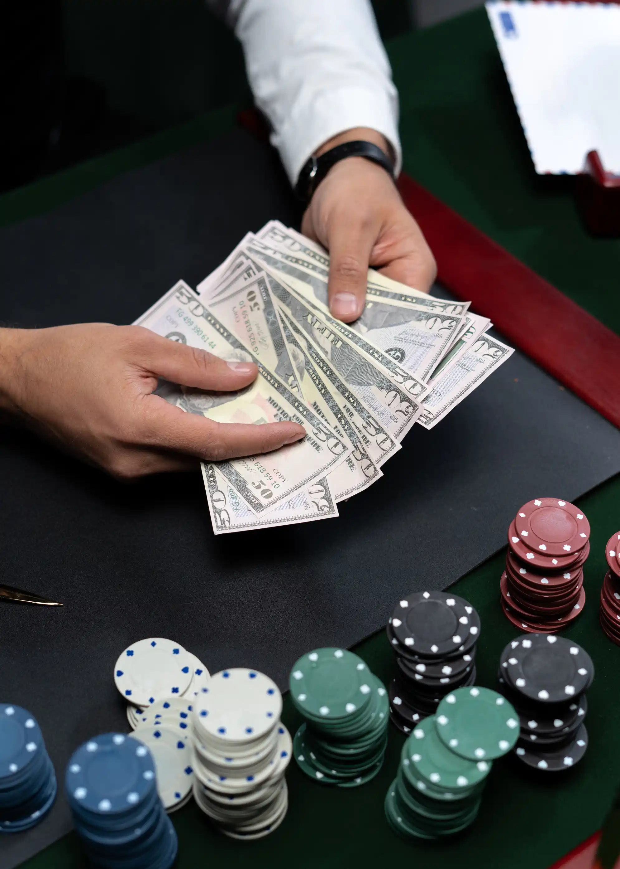 Casinodealer som teller pengesedler ved spillebordet